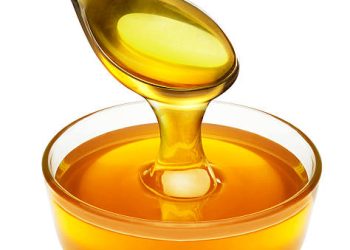 honey pouring from spoon into the bowl